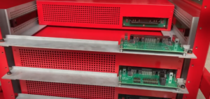 The image shows the test rack, where two modules are already in place while a third one is inserted.